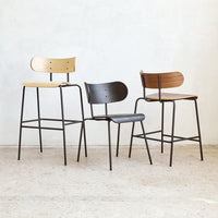 Set of three modern chairs featuring light wood, dark wood, and black finishes with sleek metal accents.