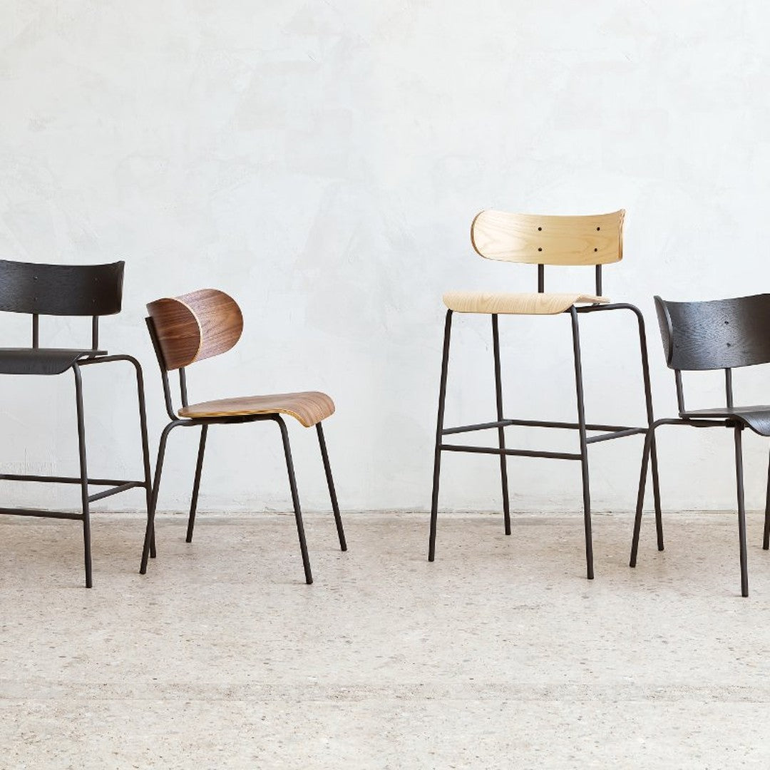 Four stylish chairs in black, brown, and natural wood tones with sleek metal frames, showcasing modern design and simplicity.