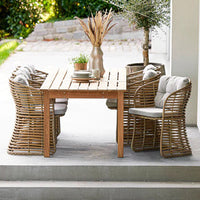 Natural wood dining table with light beige cushioned chairs, featuring a woven rattan pattern, set in an outdoor setting.