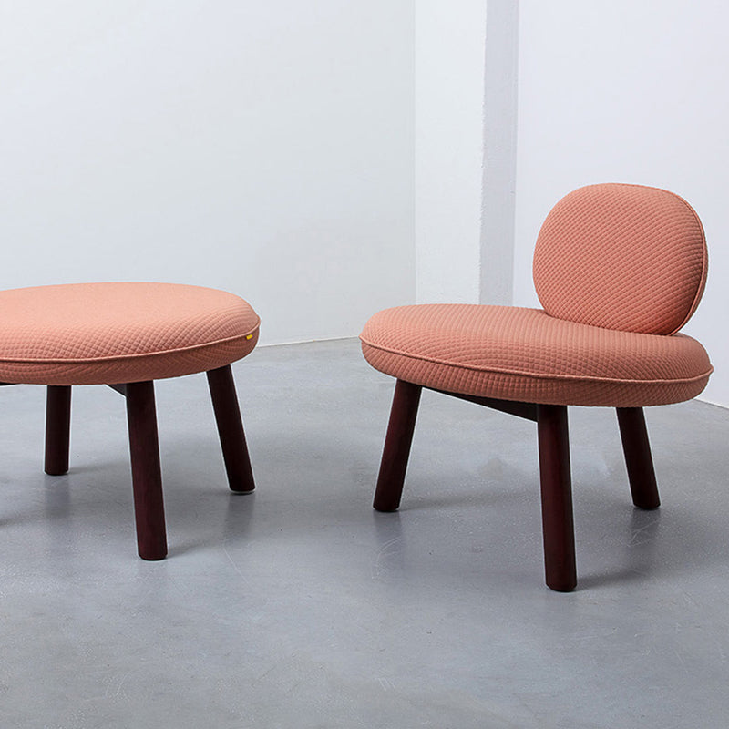 Coral pink textured seating with dark wooden legs, showcasing modern and minimalist design.