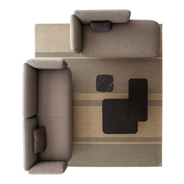 Gray sofas on a beige and brown striped area rug with black accent tables. Modern, neutral color palette.