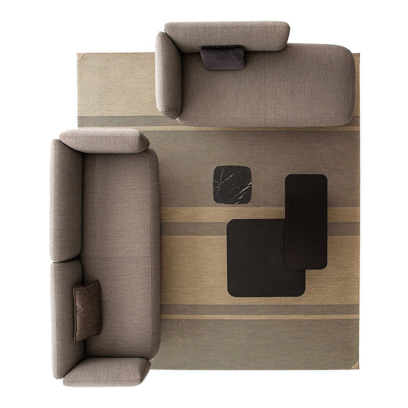 Gray sofas on a beige and brown striped area rug with black accent tables. Modern, neutral color palette.