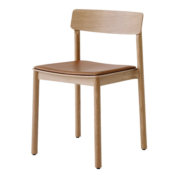 Light wood dining chair with a smooth tan leather seat and backrest, showcasing a minimalist, modern design.