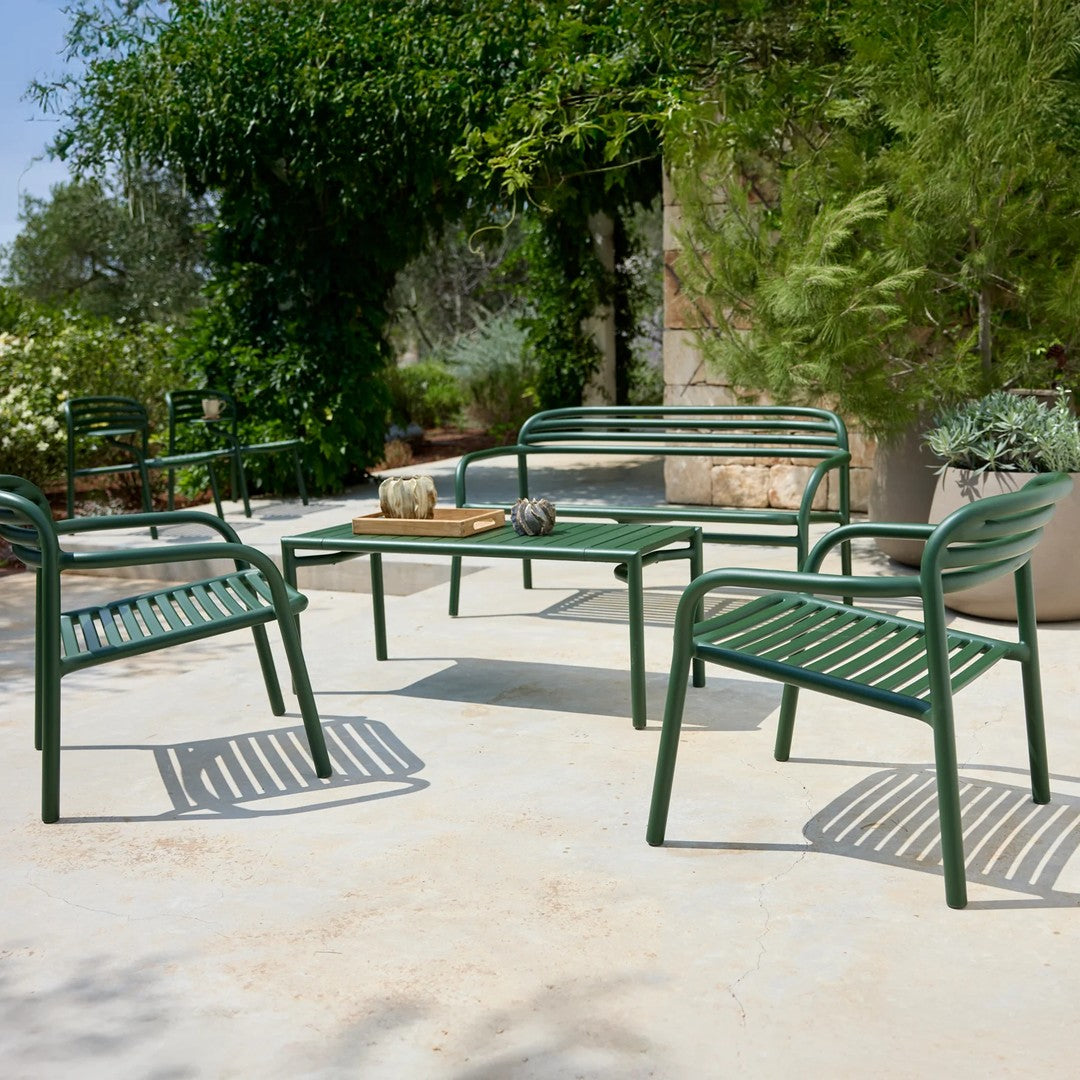 Green outdoor seating set featuring striped patterns and a sleek, modern design on a neutral patio surface.