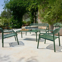 Green metal patio furniture set with slatted design, set against a natural outdoor backdrop.