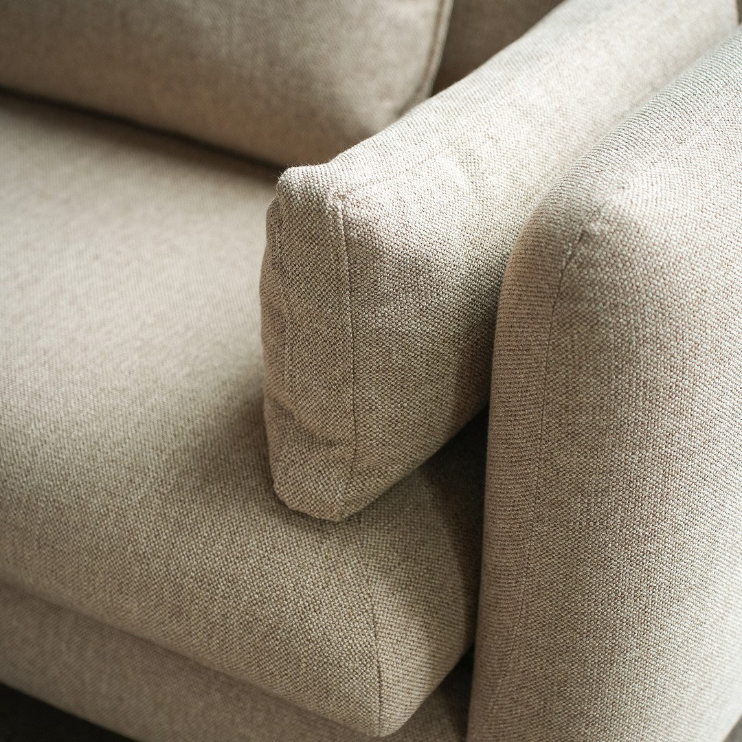 Beige textured upholstery on a cozy sofa, featuring a subtle woven pattern and soft, inviting contours.