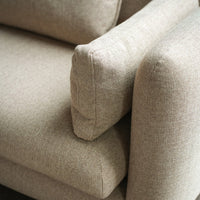 Beige textured upholstery on a cozy sofa, featuring a subtle woven pattern and soft, inviting contours.