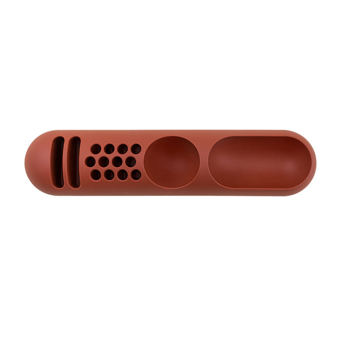 Rust-colored silicone tray with smooth surfaces and dotted, striped pattern for stylish organization.