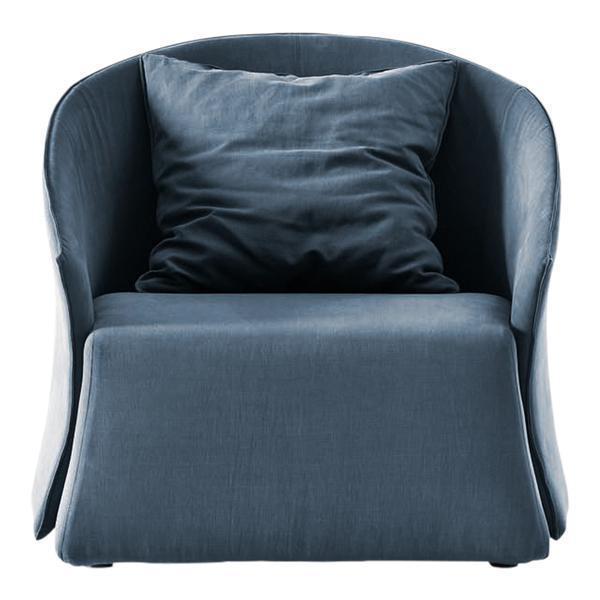 Blue velvet armchair with a smooth finish and plush cushion, featuring a modern, minimalist design.