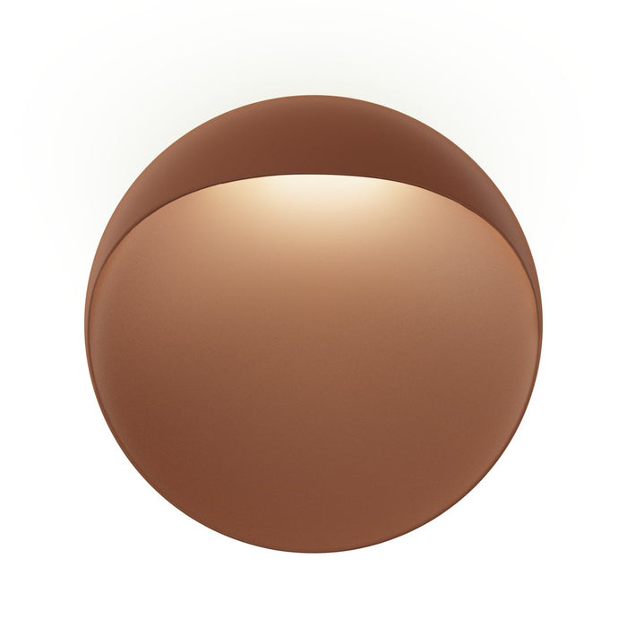 "Round ceiling light in warm bronze with a smooth, reflective surface and soft illumination."