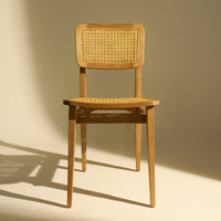Natural wood chair with woven cane seat and backrest, featuring light beige tones and a minimalist design.