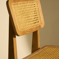 "Light wood chair with natural cane weave, featuring a warm beige and golden pattern."