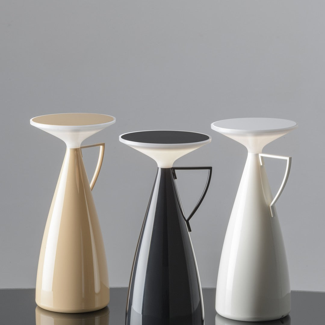 Three modern vases in beige, black, and white with smooth, glossy finishes and minimalist shapes.