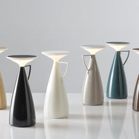 Colorful table lamps in sleek black, white, gray, teal, and brown with modern, glossy finishes and unique shapes.