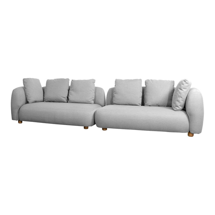 Soft grey fabric sectional sofa with plush cushions and rounded edges, featuring a subtle textured pattern and wooden legs.