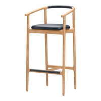 Light wood bar stool with a sleek black leather seat and black woven detail on the armrest, minimalistic design.