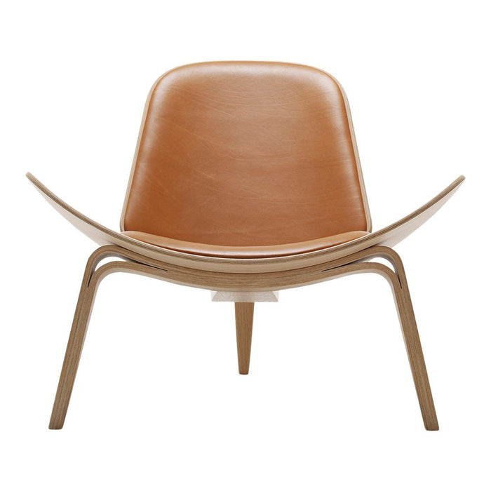 Tan leather chair with smooth, curved lines and natural wood legs, showcasing a sleek, modern design.