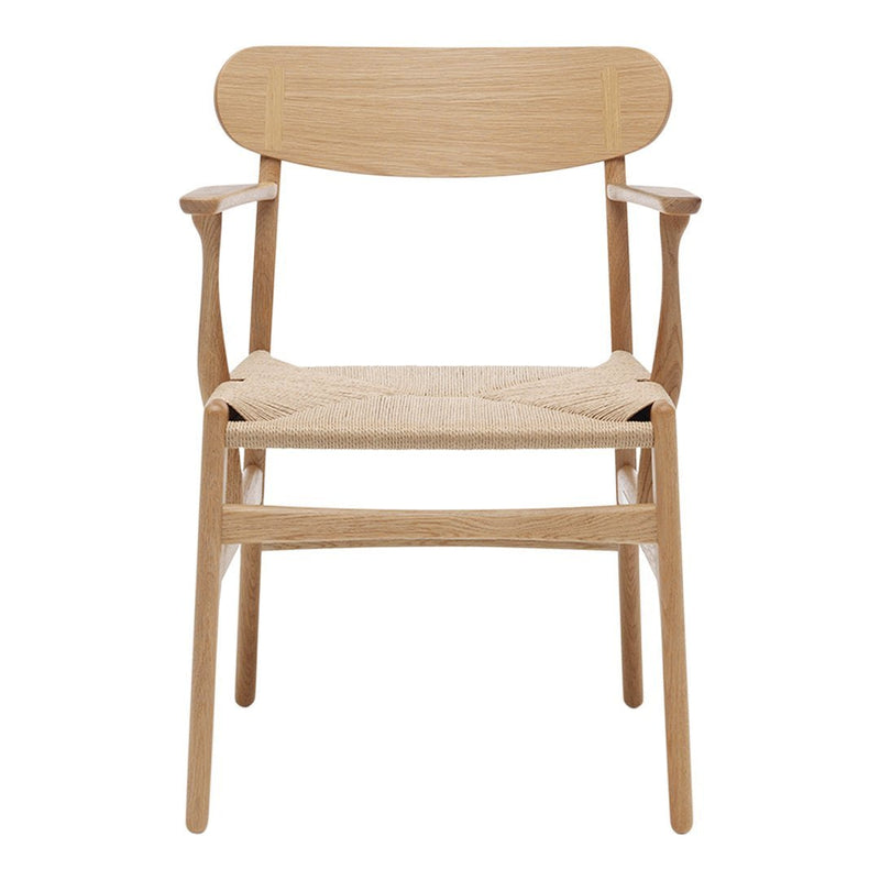 Natural wood armchair with a light finish and woven seat, showcasing minimalistic design and warm, earthy tones.