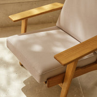 Light beige textured fabric seat cushion with natural wood armrests, showcasing a minimalist design.