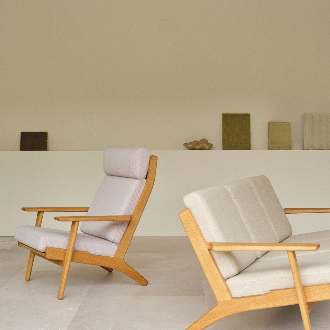"Light gray and beige upholstered chairs with natural wood frames, featuring minimalist design and soft, neutral tones."