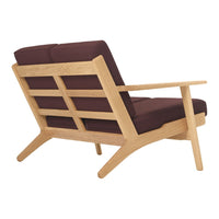 Mid-century modern armchair with a light wood frame and deep burgundy cushions, showcasing minimalist design.