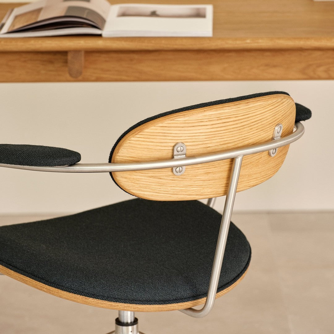 Dark green fabric and natural wood accent chair with a sleek metallic frame, showcasing modern design and textures.