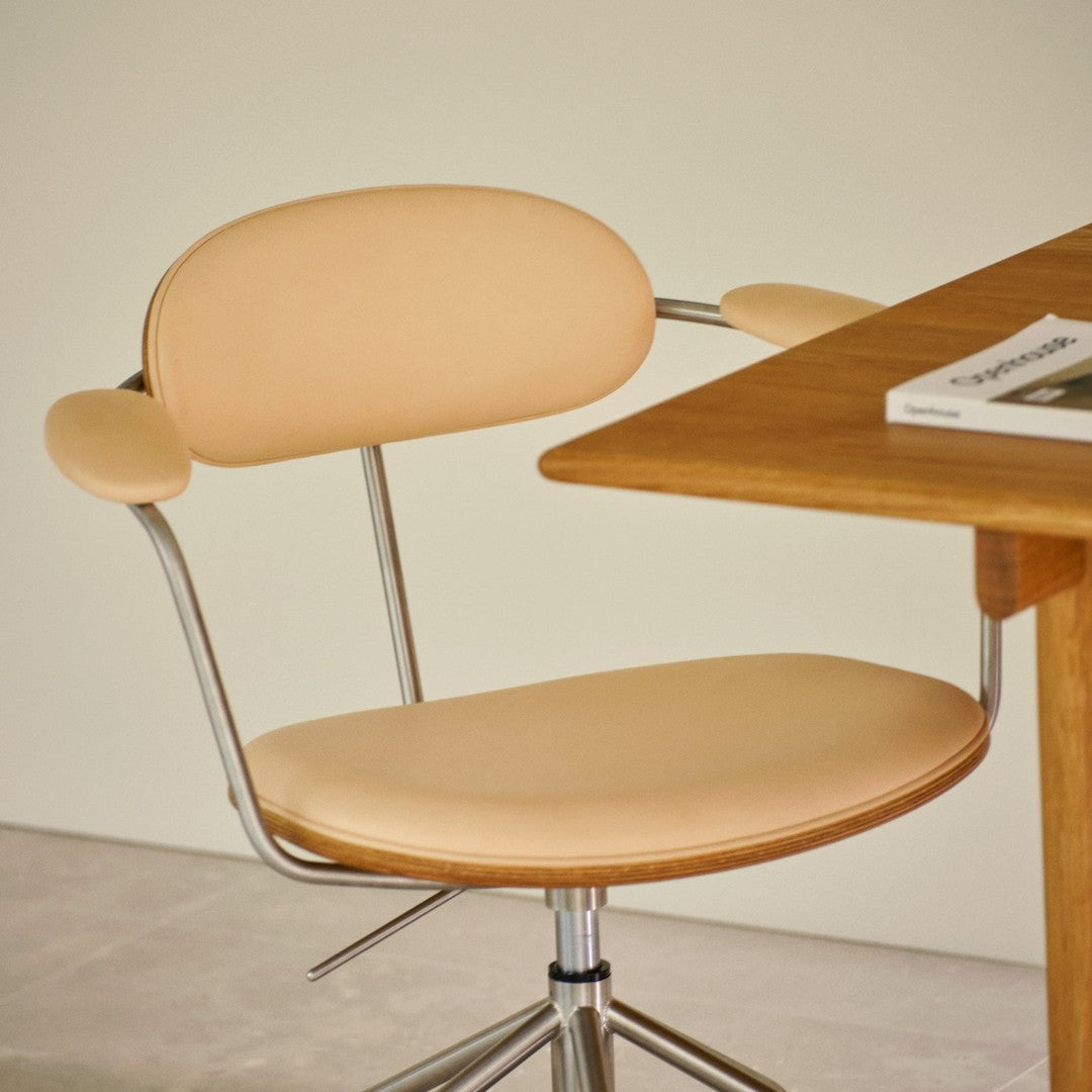 Beige padded swivel chair with a minimalist design, featuring chrome accents and a soft, smooth texture.