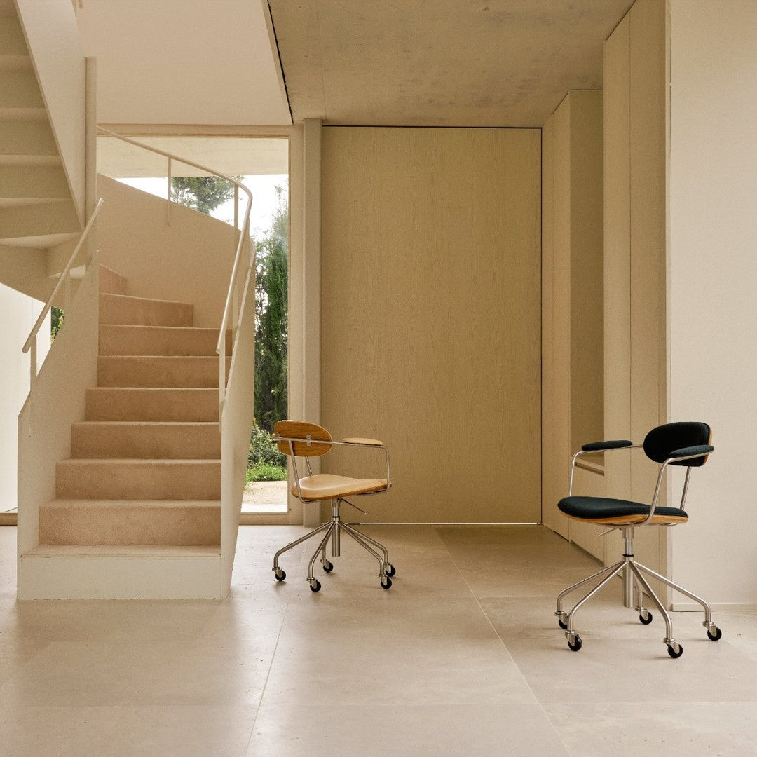 "Two modern office chairs: one in black fabric with chrome accents, the other in wood and soft tan upholstery."