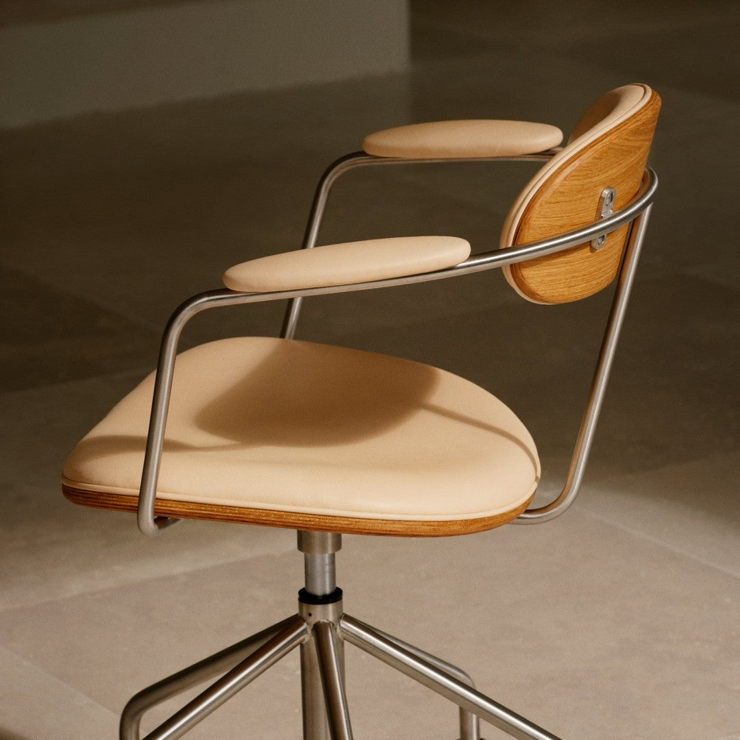 Tan upholstered swivel chair with wooden accents and sleek metal frame, showcasing a modern, minimalist design.