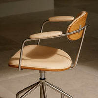 Tan upholstered swivel chair with wooden accents and sleek metal frame, showcasing a modern, minimalist design.