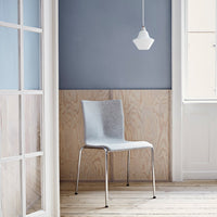 Gray upholstered chair against a blue wall and light wood paneling, creating a minimalist, modern aesthetic.