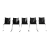 Set of five modern black chairs with sleek chrome frames, featuring a minimalist design and smooth surfaces.