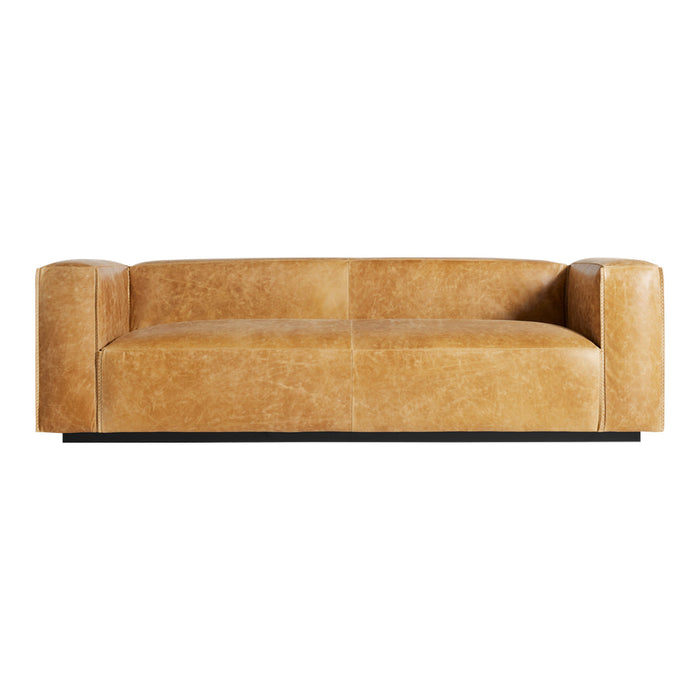 Sleek beige leather sofa with a smooth texture and minimalistic design, featuring rounded armrests and a low profile.