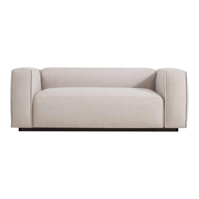 Cream-colored upholstered sofa with smooth, minimalist design and rounded armrests on a sleek black base.