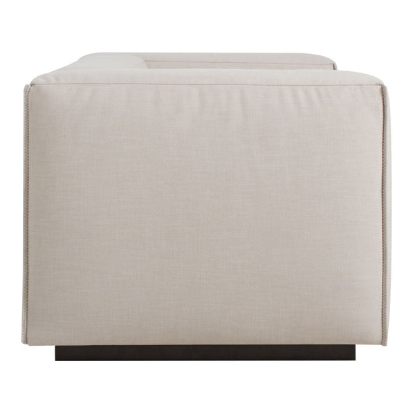 Beige rectangular ottoman with a textured fabric, featuring a sleek dark wood base. Ideal for modern decor.