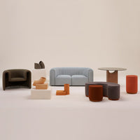 Modern furniture set featuring soft pastel blue sofa, earthy brown and terracotta accents, and smooth, neutral surfaces.