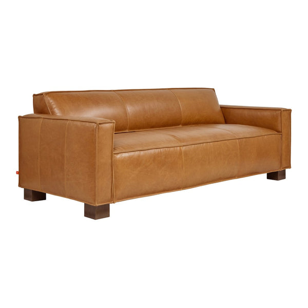 Tan leather sofa with a smooth, matte finish, featuring rectangular patterns and wooden legs for a modern look.