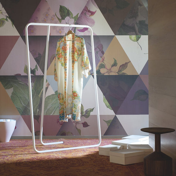 Floral patterned kimono hanging against a geometric triangle backdrop in soft pastel colors.