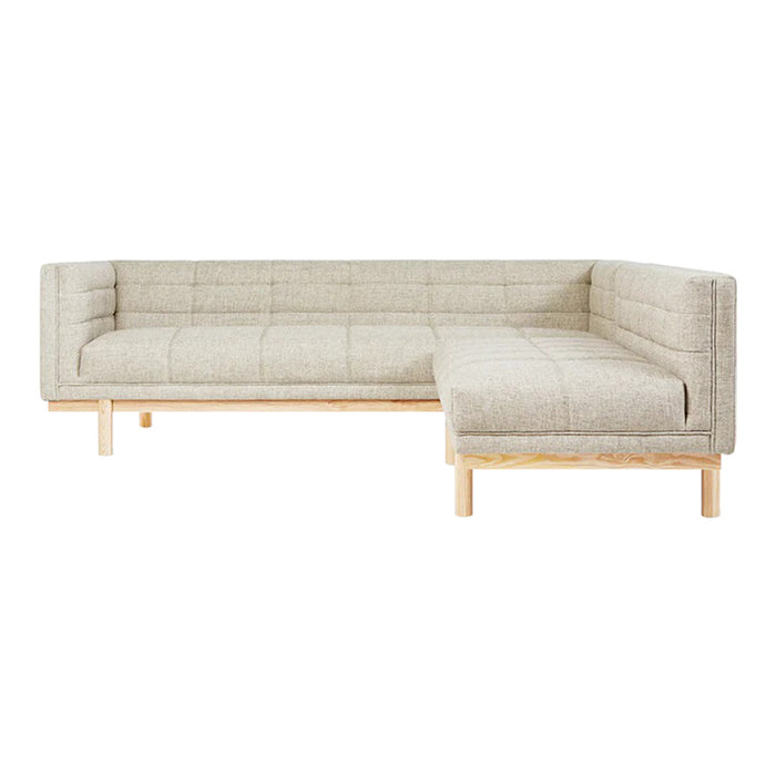 Light beige, quilted fabric sectional sofa with wooden legs, featuring a modern minimalist design.