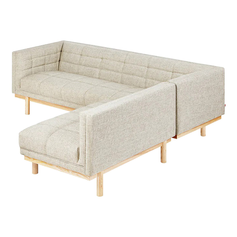 Light beige sectional sofa with a tufted pattern and natural wood legs, adding a modern touch to any living space.