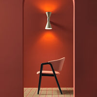 "Stylish pink chair against a warm terracotta wall, complemented by a geometric patterned floor."