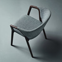 Gray upholstered chair with a smooth texture and dark wooden legs, showcasing a modern, minimalist design.
