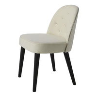 Cream upholstered chair with black wooden legs, featuring a studded pattern along the backrest.