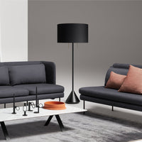 Modern living room with gray sofas, black lamp, and coral accents on cushions and tableware. Subtle neutral background.