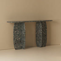 Elegant dark green console table with unique swirling patterns and smooth, polished finish against a neutral backdrop.