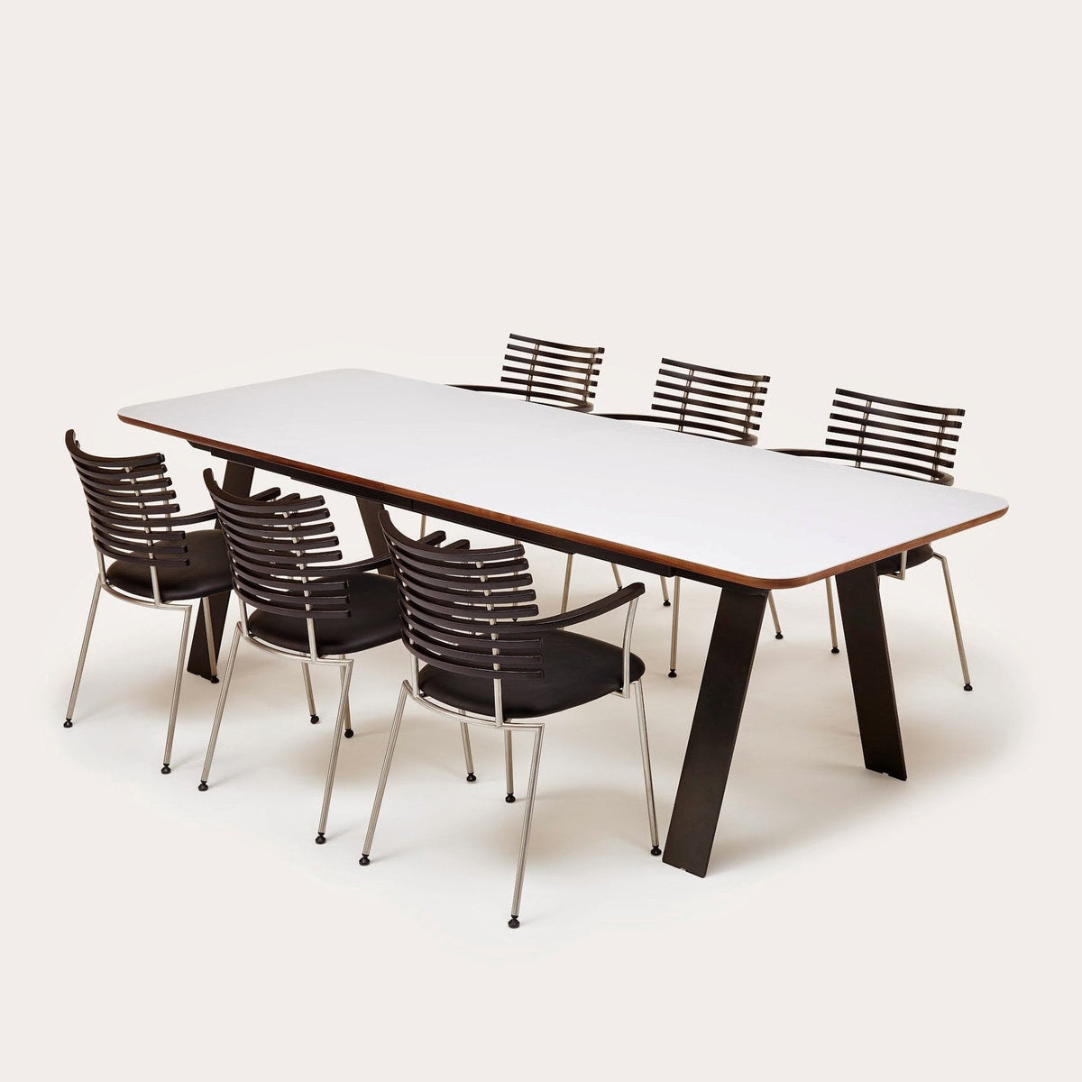 Modern white table with sleek black and silver striped chairs on a neutral background. Perfect for contemporary dining.