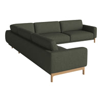 Dark green fabric L-shaped sofa with minimalist design and wooden legs. Modern and stylish for contemporary interiors.
