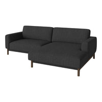 Dark gray upholstered sofa with a sleek, modern design and subtle texture, featuring brown wooden legs.