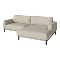 Beige sectional sofa with minimalist design and wooden legs, featuring a solid color without patterns.