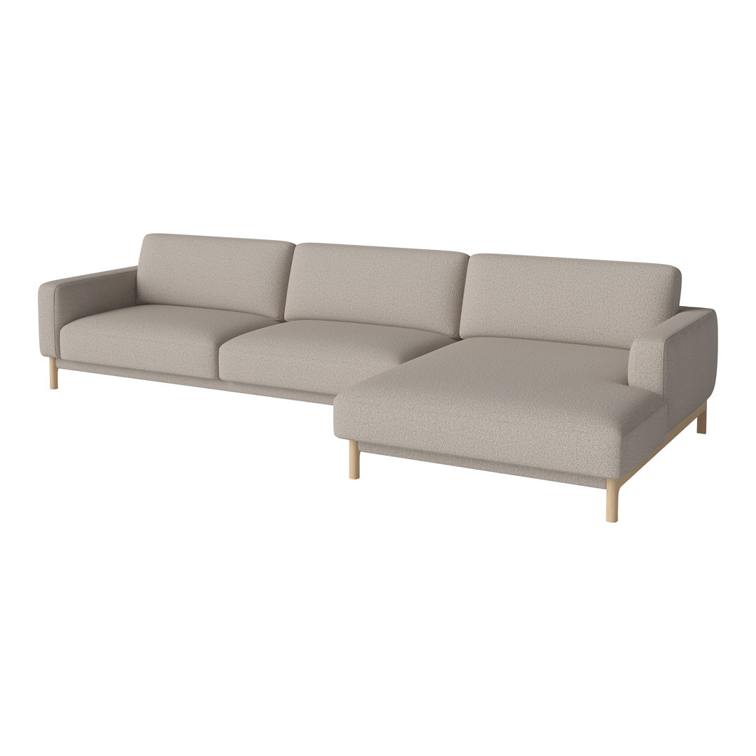 Light beige sectional sofa with a minimalist design and wooden legs, featuring smooth, monochromatic upholstery.